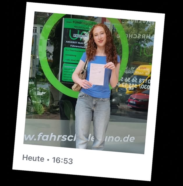 Fahrschüler mit bestandener Führerscheinprüfung vor der Fahrschule UNO