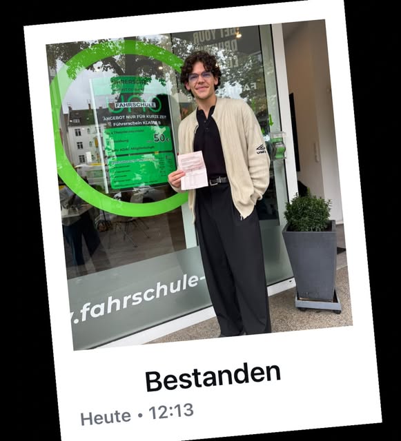 Fahrschüler mit bestandener Führerscheinprüfung vor der Fahrschule UNO