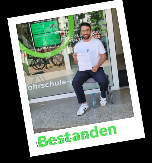 Fahrschüler mit bestandener Führerscheinprüfung vor der Fahrschule UNO